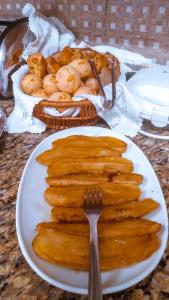 Pousada Marihá في ببرانا: صحن طعام فيه شوكة وسلة خبز