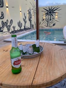 - une bouteille de bière sur une table avec une assiette de nourriture dans l'établissement Pousada Marihá, à Piranhas
