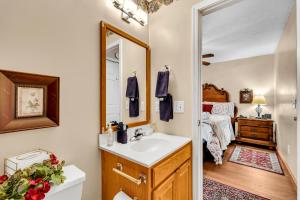 a bathroom with a sink and a mirror and a bed at Amberwood- Get 951 worth of FREE area attraction tickets for each paid day!!! in Sevierville