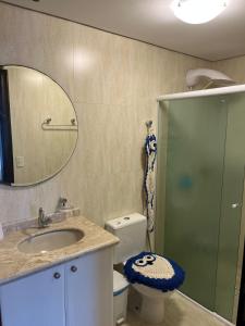 y baño con lavabo, aseo y espejo. en Apartamento Itapema SC 70m do mar, en Itapema