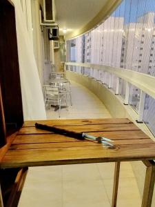 un banco de madera con un bate de béisbol en el balcón en Apartamento Itapema SC 70m do mar, en Itapema