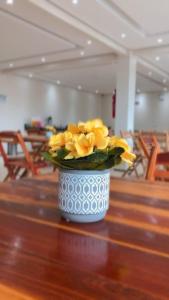 un vase rempli de fleurs jaunes assises sur une table dans l'établissement Pousada Serrana, à Ubajara