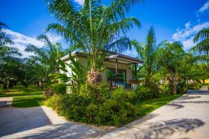 a small house with a palm tree in front of it at Palm Pran Resort in Pran Buri