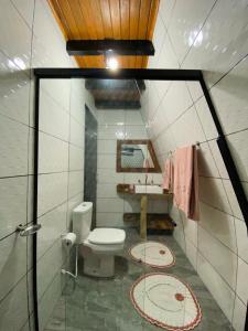 a small bathroom with a toilet and a sink at Oásis Pousada in Cambara do Sul