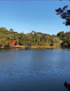 a large lake with a red barn in the middle at Oásis Pousada in Cambará