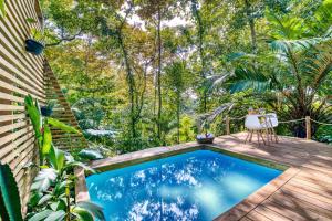 una pequeña piscina en un jardín con una mesa y una silla en Monkey Tiny House - Private swimming pool en Big Bight