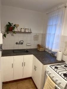 a kitchen with white cabinets and a sink and a stove at La Jarilla in Mendoza