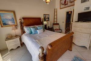a bedroom with a large bed and a television at Lovely Gulf View Walk To Beach All Appliances in Bradenton Beach