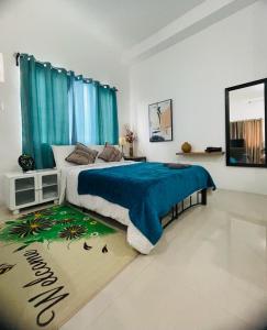een slaapkamer met een groot bed en een blauwe deken bij Deluxe studio unit at Modena Town Sq in Tunghaan