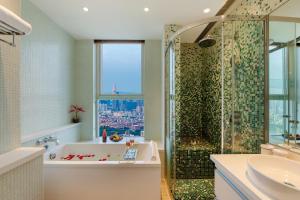 a bathroom with a shower and a tub and a sink at The Clouds Apartment in Shenzhen