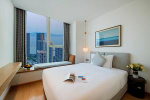 a hotel room with a large white bed and a window at The Clouds Apartment in Shenzhen