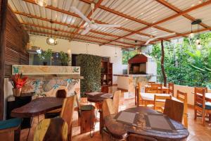 a restaurant with tables and chairs and a stove at Hotel Boutique D Angelo in Manzanillo