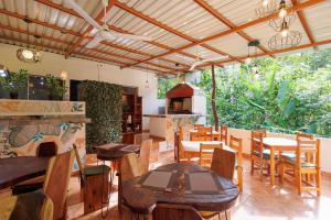 una sala da pranzo con tavoli e sedie in legno di Hotel Boutique D Angelo a Manzanillo