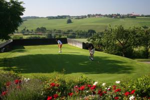 duas pessoas a jogar golfe num campo de golfe em Golf- und Landhotel Anetseder em Thyrnau