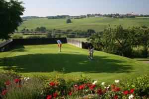 zwei Personen, die auf einem Golfplatz Golf spielen in der Unterkunft Golf- und Landhotel Anetseder in Thyrnau