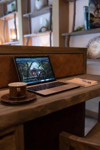 a laptop computer sitting on top of a wooden desk at Treeful Treehouse Sustainable Resort in Nago