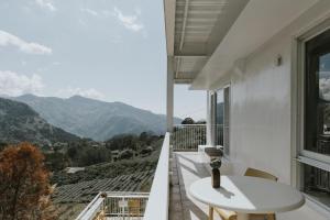 a balcony with a table and a view of mountains at Sunrise Yunqi Teahouse in Alishan