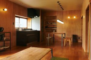 a living room with a table and a kitchen at 目の前が吉野川・雨天でも屋外体験ができる絶景の一軒家 in Ōtakuchi