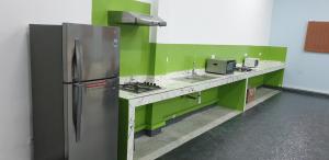 eine Küche mit grünen Wänden und einem Kühlschrank aus Edelstahl in der Unterkunft Chateau Nougat in Tameslouht