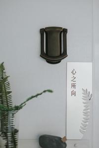 una lámpara negra colgada en una pared con una planta en Sunrise Yunqi Teahouse, en Alishan