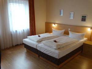 a bedroom with a large bed with white sheets at Hotel Sonne - Haus 2 in Idstein