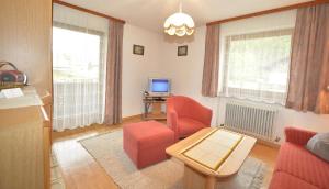 ein Wohnzimmer mit roten Stühlen und einem TV in der Unterkunft Fernblick in Leutasch