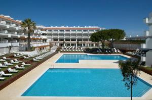a large swimming pool with lounge chairs and a hotel at Aqualuz Lagos by The Editory in Lagos