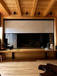 コマルニクにあるMoodySun Studio, remote tiny homeの木製天井の客室内の大きな暖炉
