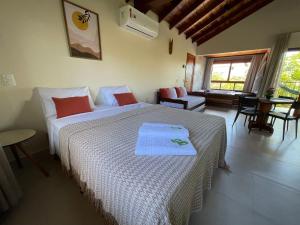 a bedroom with a bed and a room with a window at Chalés Recanto Paraíso in Alto Paraíso de Goiás