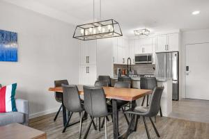 una cucina e una sala da pranzo con tavolo e sedie in legno di Beautiful Renovated Wolf 2Bed 2Bath a Canmore