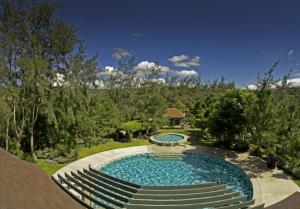a swimming pool with a fountain in a yard at Crosswinds Resort Suites in Tagaytay