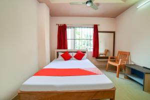 um quarto com uma cama e uma janela com cortinas vermelhas em Flagship Hotel Mayur em Dalaigaon