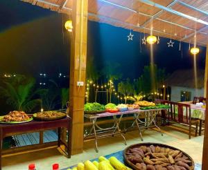 a buffet of food on a patio at night at mai chau rice fields homestay in Mai Châu