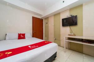 Schlafzimmer mit einem Bett und einem Flachbild-TV in der Unterkunft RedLiving Apartemen Green Lake View Ciputat - Hanna Property Tower B in Pondokcabe Hilir