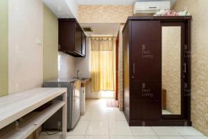 una pequeña cocina con una puerta que da a una habitación en RedLiving Apartemen Green Lake View Ciputat - Hanna Property Tower B en Pondokcabe Hilir