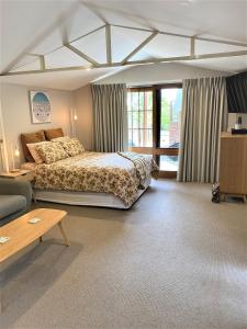 1 dormitorio con cama, sofá y mesa en The Cosy Bungalow, en Portarlington