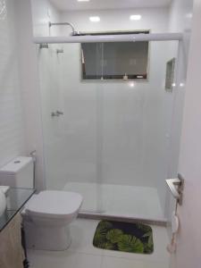 a white bathroom with a toilet and a mirror at Saquarema Itauna em frente a praia in Saquarema