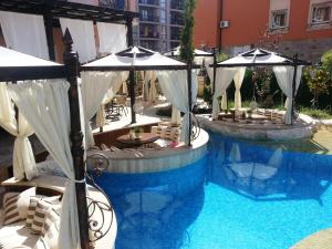 una piscina con sedie e ombrelloni in un edificio di Menada Romance Marine Apartments a Sunny Beach