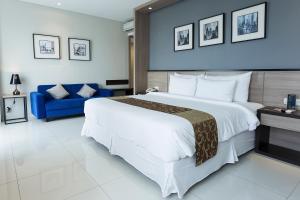a bedroom with a large bed and a blue couch at Montana Premier Senggigi in Senggigi 
