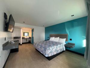 a bedroom with a bed and a blue wall at Palm Inn Los Angeles NEW in Inglewood