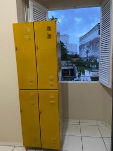 two yellow lockers in a room with a window at Hostel dos Poetas in São Luís
