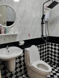 a bathroom with a white toilet and a sink at โมวิชญ์นาคาธิบดีรีสอร์ท in Ban Don Klang