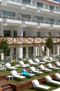 a group of lounge chairs and tables in front of a building at Aqualuz Lagos by The Editory in Lagos