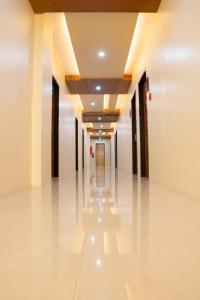 an empty corridor of a building with white floors and ceilings at Golden Suites in General Santos