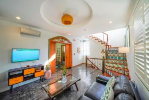 Salt Villa 3BR Oceanview An Bang Beach Hoi An في An Bàn: غرفة معيشة مع أريكة وتلفزيون