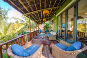 een veranda met rieten stoelen en een tafel bij Salt Villa 3BR Oceanview An Bang Beach Hoi An in An Bàn (2)