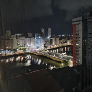 una ciudad de noche con un puente sobre un río en Rua da Aurora, en Recife