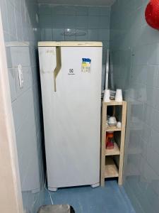 a white refrigerator in a kitchen next to a shelf at Rua da Aurora in Recife