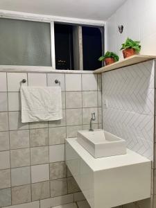 baño blanco con lavabo y ventana en Rua da Aurora, en Recife