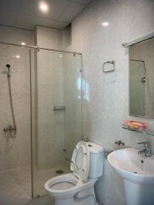 a bathroom with a shower and a toilet and a sink at Lotus Apartment Hotel in Vung Tau